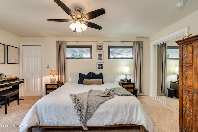 bedroom featuring light colored carpet, a ceiling fan, and multiple windows