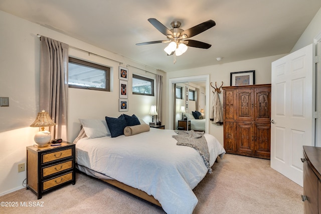 bedroom with light colored carpet and a ceiling fan