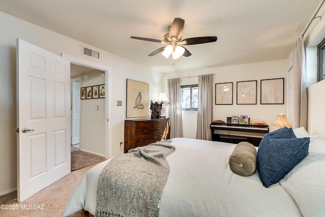 carpeted bedroom with visible vents, baseboards, and ceiling fan