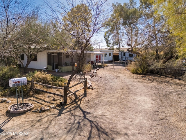 ranch-style home featuring driveway and fence