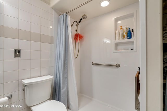 full bath with a shower stall, toilet, and tile walls