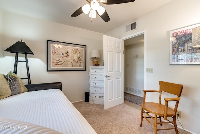 bedroom featuring visible vents, light colored carpet, baseboards, and ceiling fan