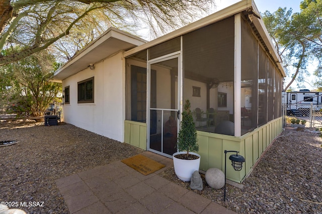 view of property exterior with a sunroom