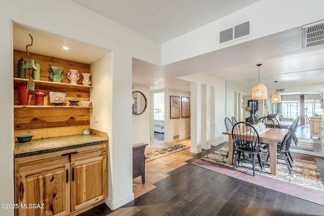 dining area with baseboards, visible vents, and dark wood-style flooring