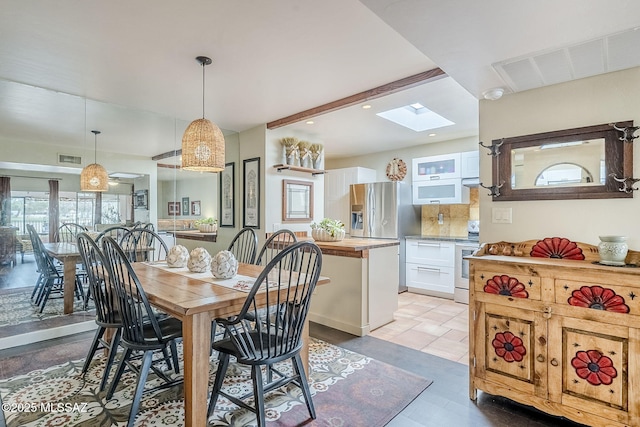 dining space with a skylight, beam ceiling, visible vents, and recessed lighting