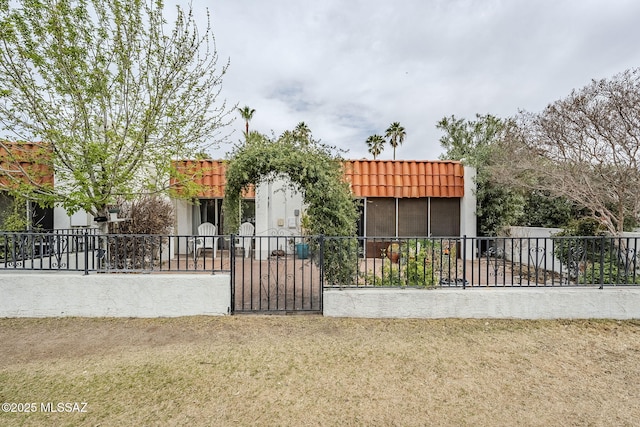 view of front of house featuring fence and a tiled roof