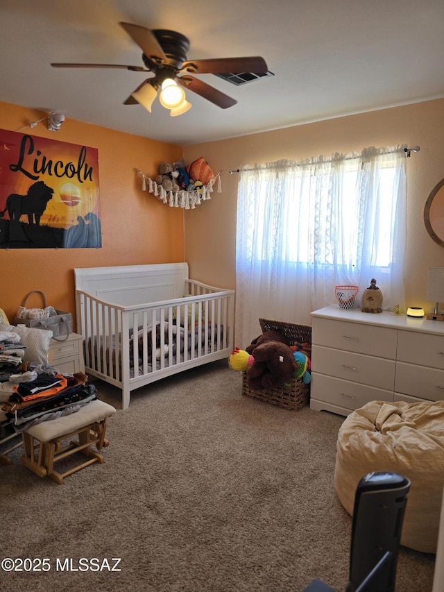 carpeted bedroom featuring multiple windows and ceiling fan