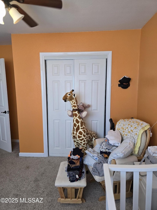 carpeted bedroom with a closet, baseboards, and a ceiling fan