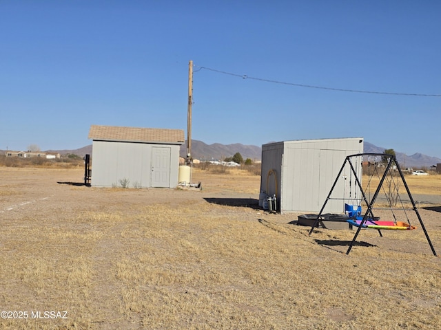 view of yard with a storage unit, an outbuilding, and a mountain view