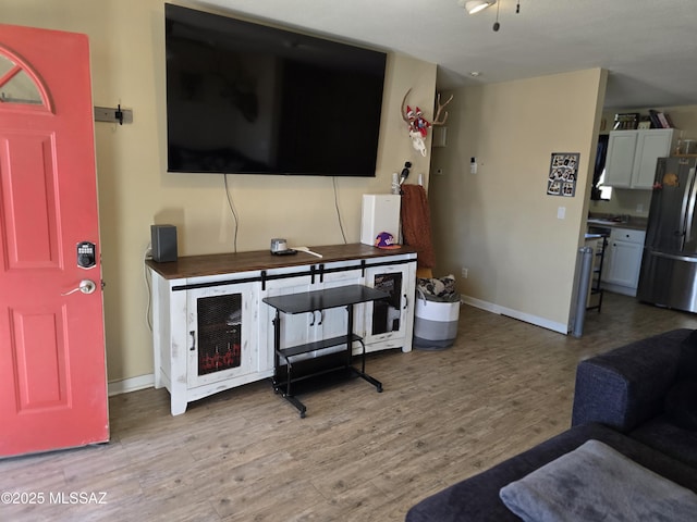 living room with light wood-type flooring and baseboards