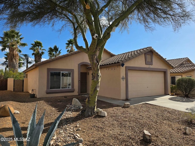 view of front of home with a tiled roof, stucco siding, driveway, and an attached garage