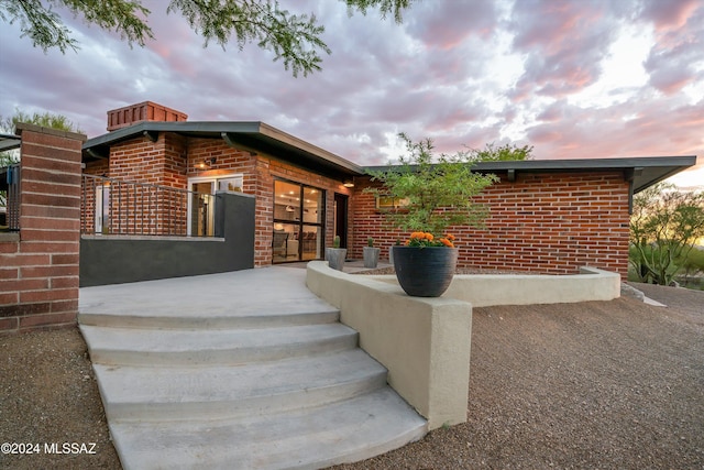 entrance to property featuring brick siding