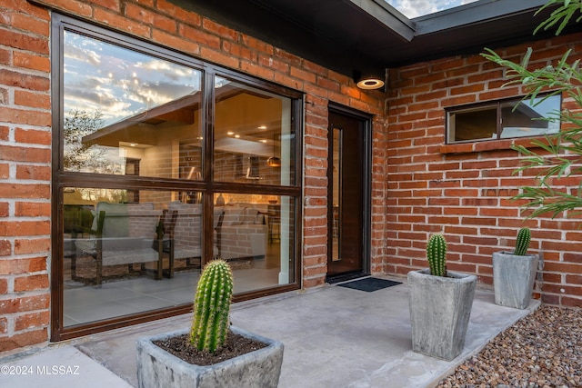 entrance to property featuring brick siding