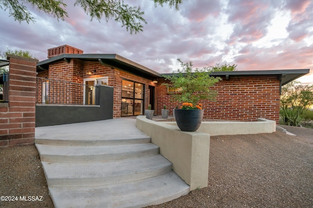 property entrance featuring brick siding