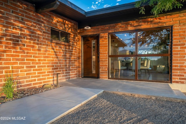 view of front of property featuring fence, an attached garage, board and batten siding, driveway, and brick siding