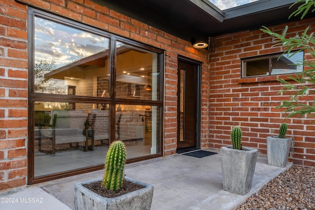 view of exterior entry with brick siding