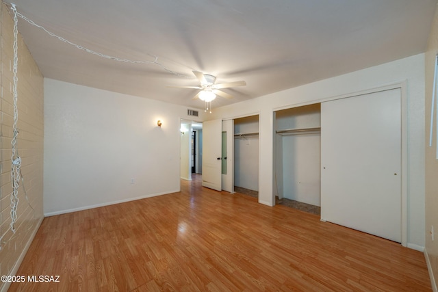 418 N Calle De Las Profetas, Green Valley, AZ 85614 - unfurnished bedroom with multiple closets, light wood-type flooring, a ceiling fan, and baseboards
