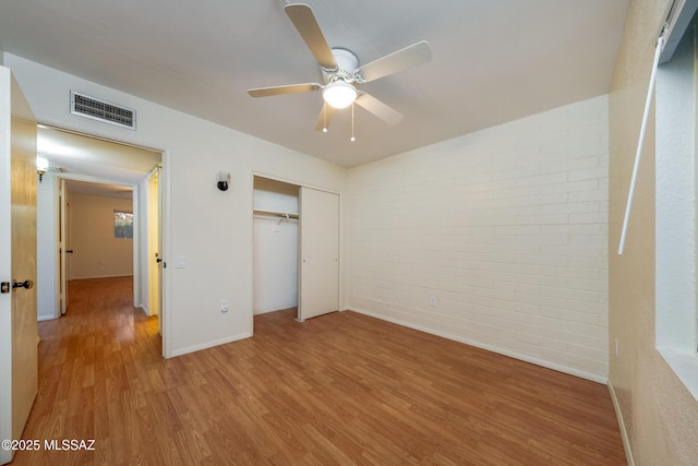 418 N Calle De Las Profetas, Green Valley, AZ 85614 - unfurnished bedroom featuring brick wall, wood finished floors, baseboards, a closet, and ceiling fan