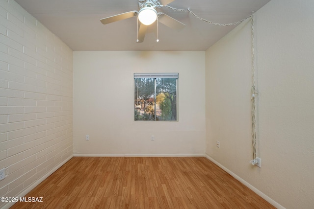 418 N Calle De Las Profetas, Green Valley, AZ 85614 - unfurnished room with light wood-type flooring, a ceiling fan, baseboards, and brick wall