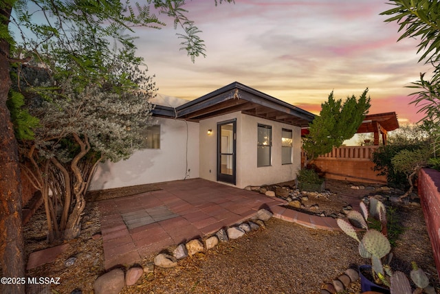 418 N Calle De Las Profetas, Green Valley, AZ 85614 - back of house at dusk with stucco siding, a patio area, and fence