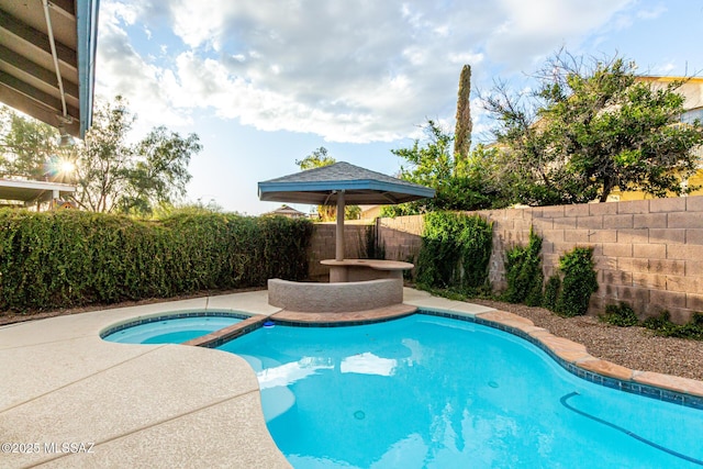 view of pool with a pool with connected hot tub and a fenced backyard