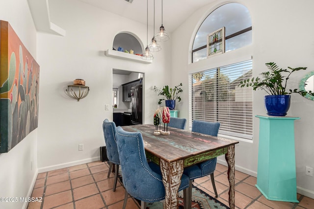 dining room with a high ceiling and baseboards