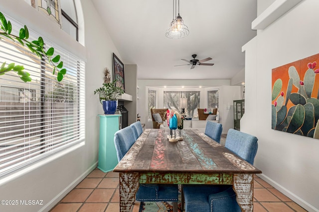 dining area featuring a ceiling fan, baseboards, and light tile patterned floors