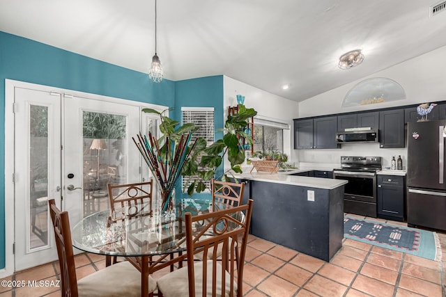 kitchen featuring lofted ceiling, appliances with stainless steel finishes, a peninsula, light countertops, and light tile patterned flooring