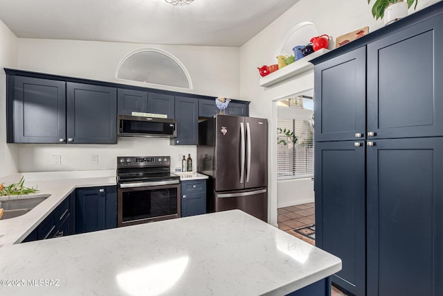 kitchen with stainless steel appliances, a sink, a peninsula, and light stone countertops