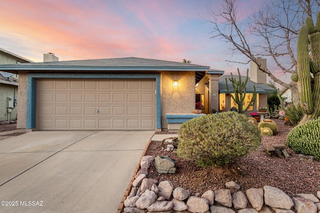 view of front of house with driveway, an attached garage, and stucco siding