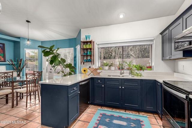 kitchen featuring a peninsula, stainless steel appliances, a sink, hanging light fixtures, and light countertops