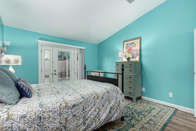 bedroom with visible vents, baseboards, lofted ceiling, wood finished floors, and access to exterior