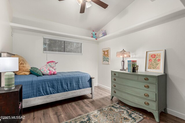 bedroom with a ceiling fan, baseboards, vaulted ceiling, and wood finished floors