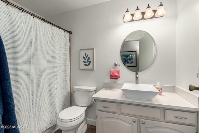 full bathroom with curtained shower, vanity, and toilet