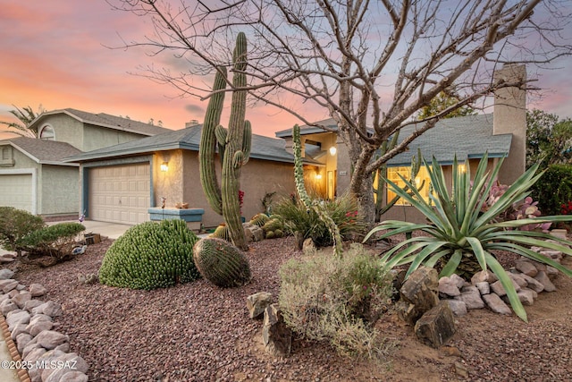 view of front facade featuring a garage, driveway, and stucco siding