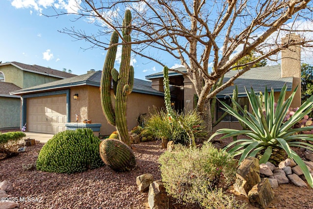 view of front of property featuring a garage, driveway, and stucco siding