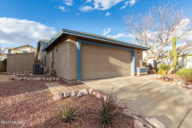 view of side of property with stucco siding, fence, a garage, cooling unit, and driveway