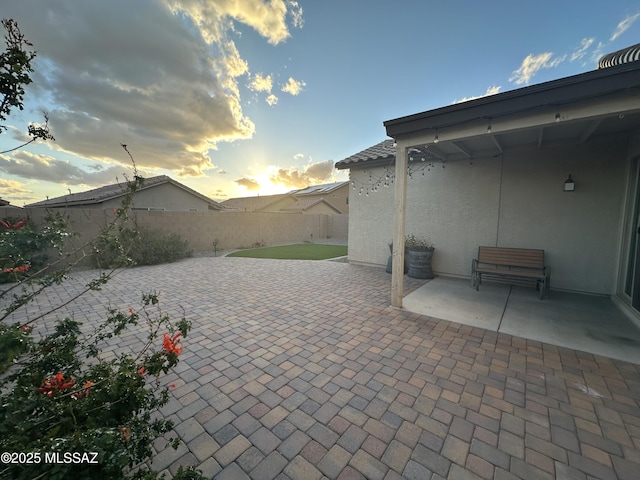patio terrace at dusk with a fenced backyard
