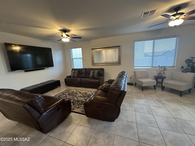 living area featuring light tile patterned floors, visible vents, and a ceiling fan