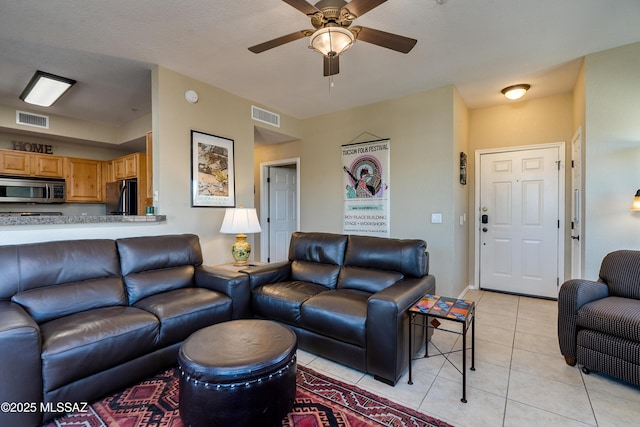 living area with visible vents, ceiling fan, and light tile patterned floors