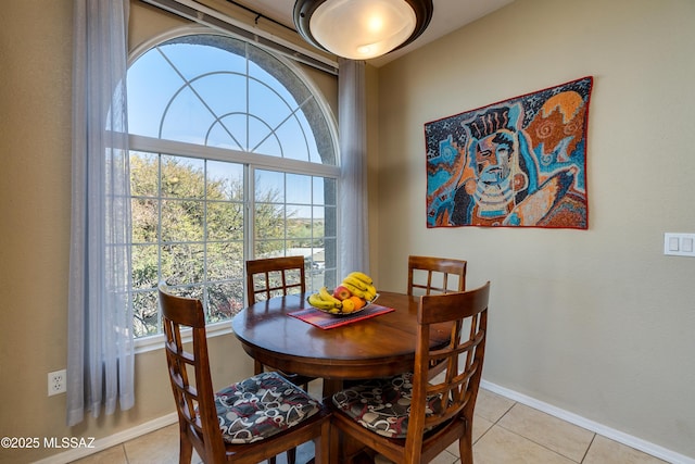 dining space featuring baseboards and light tile patterned flooring