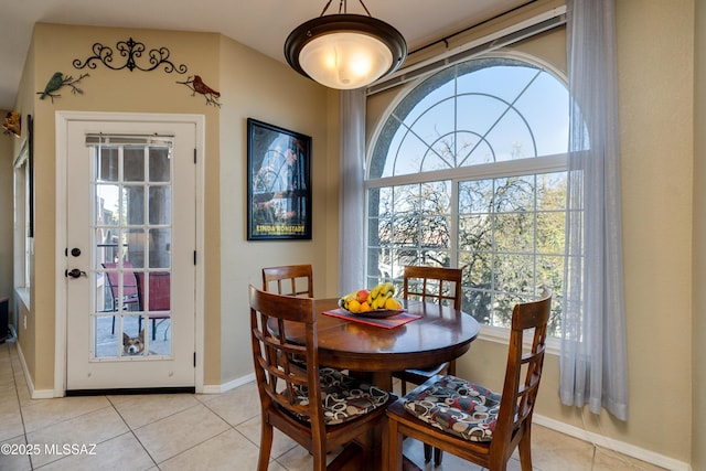 dining space with light tile patterned floors and baseboards