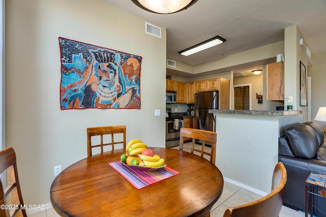 dining space with light tile patterned flooring and visible vents