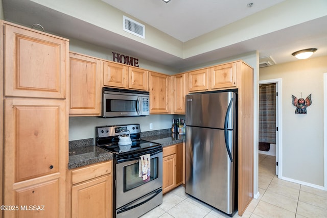 kitchen with light tile patterned floors, visible vents, tile counters, stainless steel appliances, and light brown cabinetry