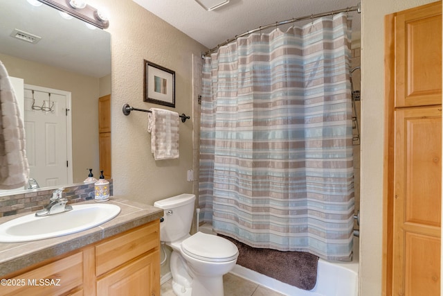 bathroom featuring visible vents, a textured wall, toilet, tile patterned flooring, and vanity