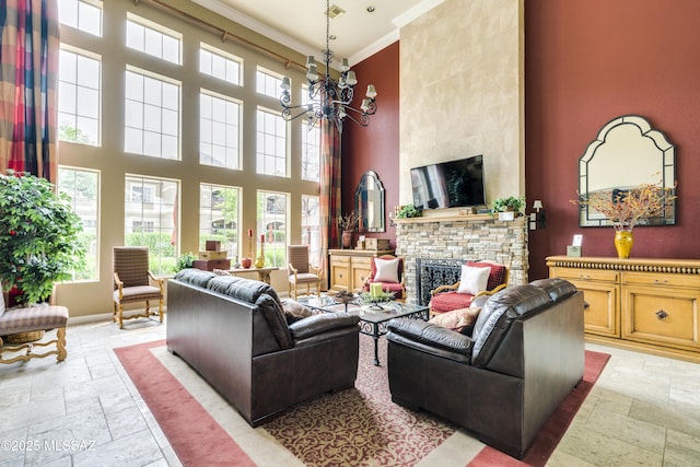 living area featuring a fireplace, a notable chandelier, stone tile flooring, a towering ceiling, and ornamental molding