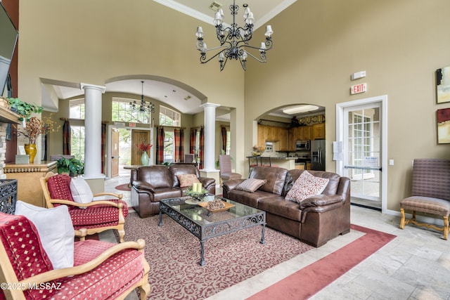 living area featuring ornate columns, stone tile floors, a chandelier, and arched walkways