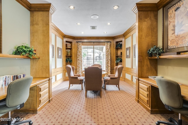 office area featuring built in shelves, light carpet, visible vents, ornamental molding, and built in desk