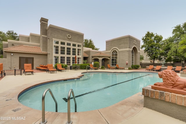 pool with a patio area and fence