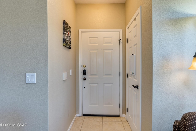 doorway to outside with baseboards and light tile patterned floors